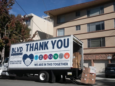 A moving truck with COVID-19 aware messaging outside of an apartment building in Oakland on Nov. 7, 2020.