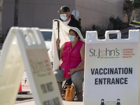 Jose Rosas and his wife, Sara, who live in the 90060 ZIP code, wait in line to be vaccinated at the St. John's Well Child and Family Center in Los Angeles on March 4, 2021. \