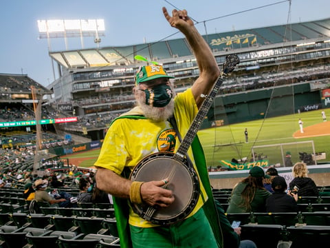 San Francisco resident Stacy Samuels, also known as Super A or Banjo Man, plays the banjo while cheering in the stands. Samuels, who has been bringing his banjo to Athletics games for more than 30 years, said “It’s great.
