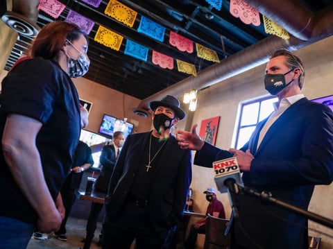 Magaly Colelli owner of Magaly's restaurant talks with Gov. Gavin Newsom and actors Danny Trejo in San Fernando, Calif. Thursday, April 29, 2021.