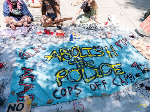 A group paints signs calling for the abolition of police on the UC Davis Campus, Monday, May 3, 2021.