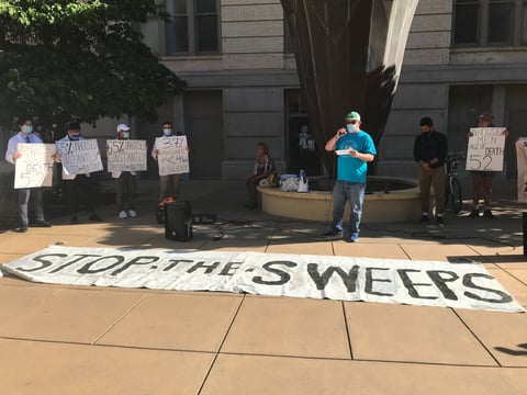 Joe Smith, advocacy director of Loaves and Fishes, speaks to a crowd at a Tuesday rally about the need for safe sites for homeless individuals. During most of the pandemic, a public health order has allowed people to sleep in their tents and cars.