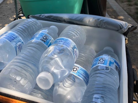 Amy Mattingly brings coolers full of water bottles to hand out to unhoused people in Cesar Chavez Park in Sacramento.
