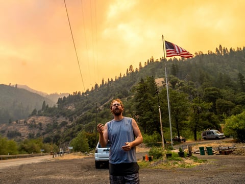 Benjamin Bell watches as the Dixie Fire burns along Highway 70 in Plumas National Forest, Calif., on Friday, July 16, 2021.