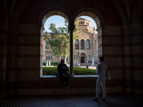 Students sit outside of Royce Hall at UCLA — among the University of California campuses that could experience tuition hikes every year under a pending proposal.