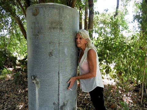 Kelly O’Brien listens to her well hum as it fills with cool water after more than a month of living without water at her home on July 2, 2021.