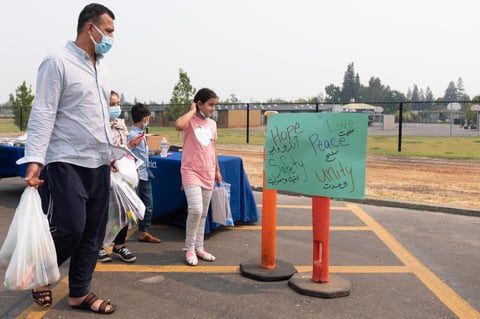 Abdul Azizi and his children attend a food distribution and resource fair at Encina High School Thursday, Aug. 19, 2021.