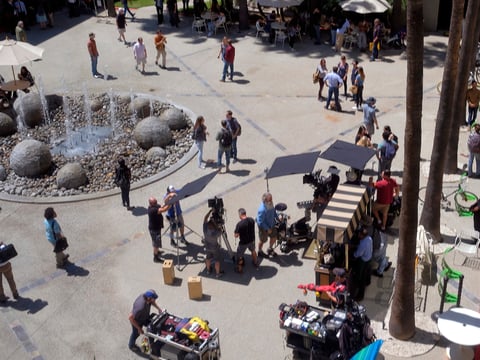 In this May 1, 2017 file photo production crew, extras, and camera operators get ready to film an episode of NCIS:Los Angeles on location in Los Angeles.