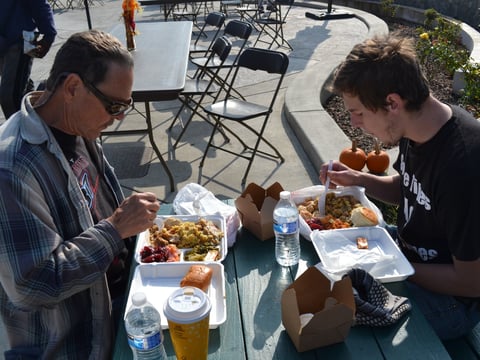 Rich Mann and his son, Luke, enjoy a Thanksgiving meal at Loaves & Fishes in Sacramento. The center has provided holiday meals and assisted homeless residents with many other services for nearly four decades.