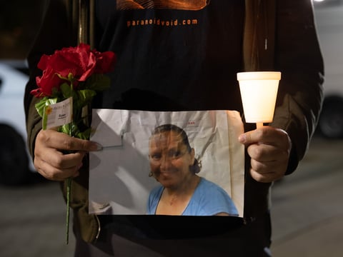 Nick Garcia holds up a picture of Melinda Davis at a vigil on Monday April 4, 2022.
