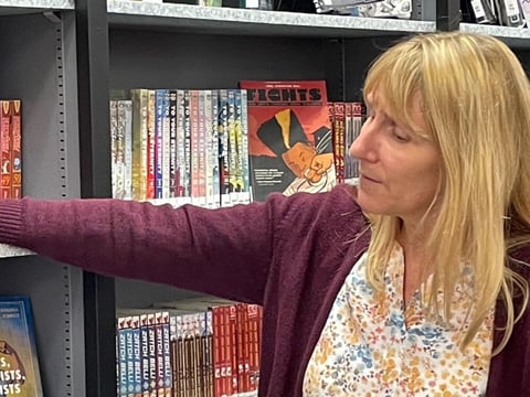 Susan Sloan, a credentialed teacher librarian, shows off the collection of books at Bella Vista High School in Sacramento.