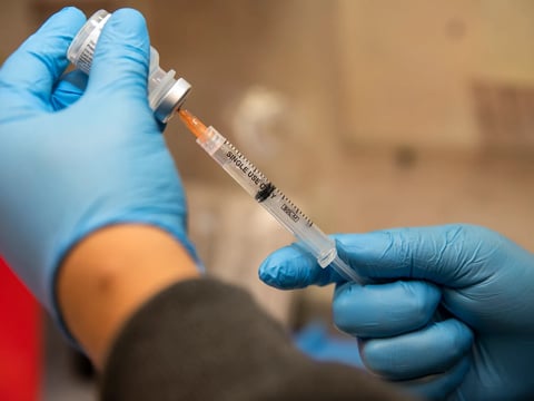 A nurse draws up a dose of the COVID-19 vaccine at a mobile health clinic in Los Angeles on March 16, 2022.