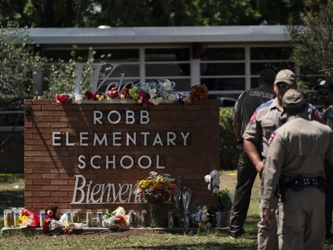 Flowers and candles are placed outside Robb Elementary School in Uvalde, Texas, on Wednesday to honor the victims killed in Tuesday's shooting at the school.