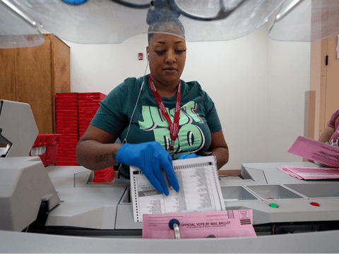 Election worker Antoinette Heckard removes a mail-in ballot from an envelope for the California Primary election at the Sacramento County Registrar of Voters in Sacramento, Calif., Friday, June 3, 2022.