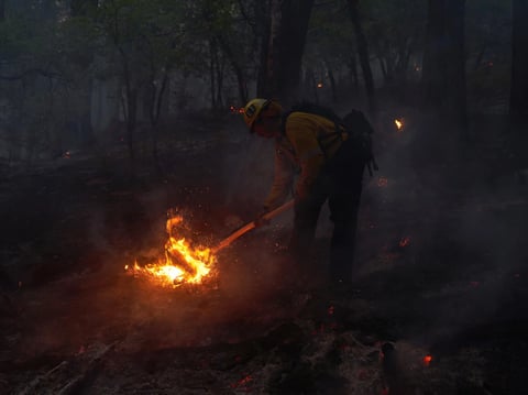 Firefighters battle flames as the Dixie Fire pushes through the Genesee Valley in California in August 2021. The fire was California's largest single wildfire in recorded history, burning nearly 1 million acres.