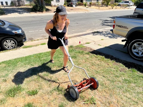 Sacramento resident Shawnecee Schneider uses a push mower to cut the grass in front of her Fruitridge Manor home. Soon, she's swapping out the lawn for drought-friendly landscaping through the city's Turf Replacement program.