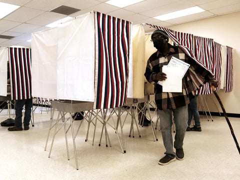 People cast early ballots in the upcoming midterm elections at a polling station on Tuesday in Anchorage, Alaska.