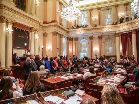 New California legislators stand to take the oath of office in the Senate chambers in the state Capitol on Dec. 5, 2022.