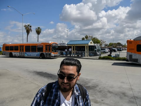 Henry Sanchez, 22, who lives in Bell Gardens, waits for the Metro bus to arrive at the Norwalk Green Line Station in Norwalk on April 3, 2023.