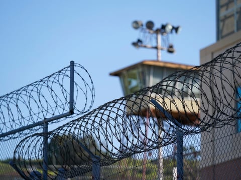 Razor wire is seen below a guard tower at San Quentin State Prison in San Quentin, Calif., Friday, March 17, 2023.