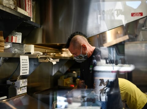 A kitchen staffer works behind the counter of a restaurant in Los Angeles on June 8, 2021.
