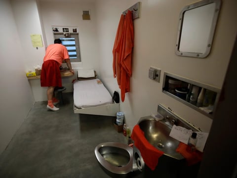 A person looks out a window in his solitary confinement cell at the Main Jail in San Jose, Calif., on Dec. 16, 2019.