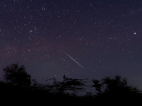 This photo taken late December 14, 2018 with a long time exposure shows a meteor streaking through the night sky over Myanmar during the Geminid meteor shower seen from Wundwin township near Mandalay city.