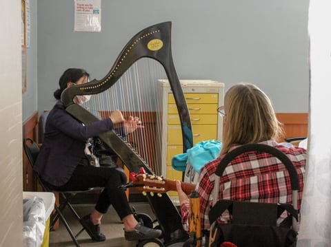 Music Practitioners Carol Ng and Mary Superak perform at a cancer patient's bedside at the Mercy San Juan Medical Center in Carmichael on Thursday, Dec. 14, 2023.
