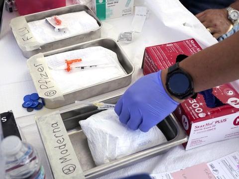 Syringes with vaccines are prepared at the L.A. Care and Blue Shield of California Promise Health Plans' Community Resource Center where they were offering members and the public free flu and COVID-19 vaccines Oct. 28, 2022, in Lynwood, Calif.