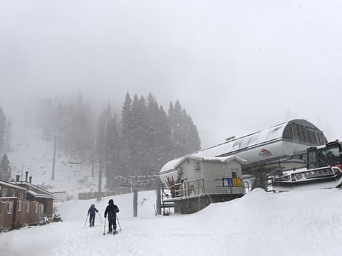 People snowshoe next to the ski lift at Palisades Tahoe on Wednesday, Jan. 10, 2024, in Tahoe, Calif.