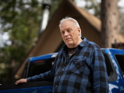 Bill King stands outside his home in Arrowbear Lake, a community near Running Springs, on Jan. 15, 2024.