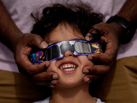 Viewers use special glasses to watch from San Antonio, as the moon moves in front of the sun during an annular solar eclipse, or ring of fire, Oct. 14, 2023.
