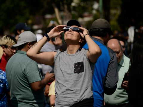 A woman watches an annular solar eclipse on October 14, 2023 using special solar filter glasses at the National Autonomous University of Mexico.