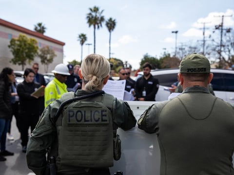 Department of Cannabis Control detectives, with Long Beach law enforcement, prepare to serve a search warrant on an unlicensed marijuana store in Long Beach, Calif., on March 5, 2024.