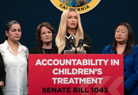 Hotel heiress and media personalty Paris Hilton, center, discusses a proposed bill calling on more transparency for youth treatment facilities during a news conference in Sacramento, Calif., Monday, April 15, 2024.