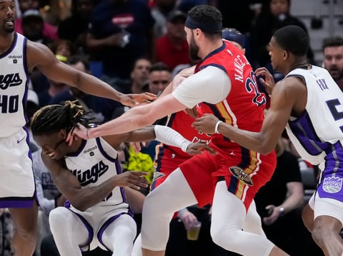 New Orleans Pelicans forward Larry Nance Jr. shoves Sacramento Kings guard Keon Ellis in the face as they battle for a loose ball in the first half of an NBA basketball play-in tournament game in New Orleans, Friday, April 19, 2024.