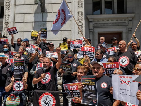 Ride-share driver and SEIU Gig Workers Union member John Mejia, center, speaks during a press conference outside of the Supreme Court of California in San Francisco on May 21, 2024.