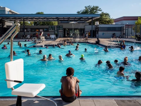 A child watches others swim at the Emancipation Swimming Pool in Houston on July 19, 2022.