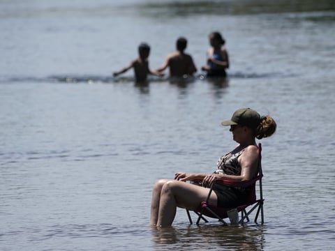 Dianna Andaya, relaxes in the cooling water of the American River as the temperature climbed over the 100 degree mark in Sacramento, Calif., Friday, June 10, 2022.