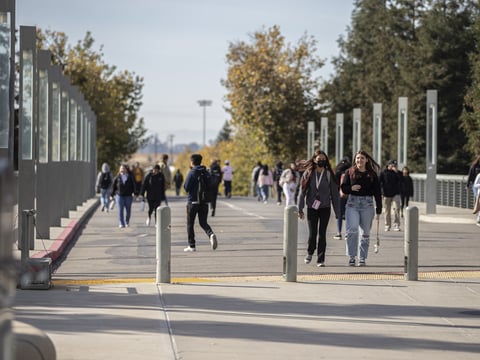 Students walk along the bridge leading into campus on Scholars Lane at the University of California Merced campus on Nov. 4, 2022.