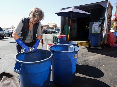 In this Tuesday, July 5, 2016, file photo, Claudette Cole places a plastic bottle into a plastic container for recycling at a recycling center in Sacramento, Calif.