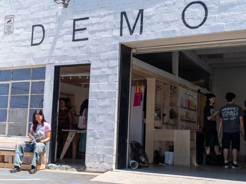 Esther Wang (far left), sits outside Demo Art & Books that opened to the public May 10.