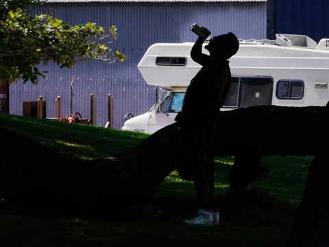 A man drinks water during a heat wave in Los Angeles on July 13, 2023.