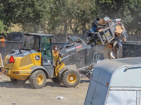 A bulldozer throws away the trash and belongings left behind by residents Monday, Aug. 26, 2024, at Camp Resolution in Sacramento.