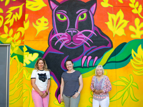 From left, Sacramento City College Prof. Gioia Fonda and students Megan Bernards and Jennifer Tachera stand in front of a mural depicting the college’s panther mascot on Aug. 26. The mural was created with art students at the college.