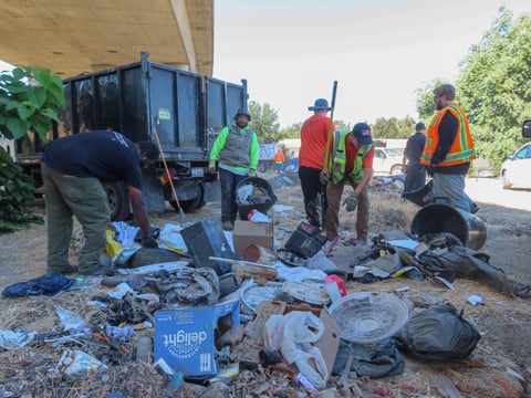Sacramento Department of Community Response staff clear a trash pile near an encampment next to the former Camp Resolution site on Wednesday, Sept. 4, 2024, in Sacramento.