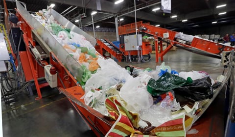 Conveyors carry mixed plastic into a device that will shred recycle them at a plastics recycling plant in Vernon, Calif. Jan. 24, 2014