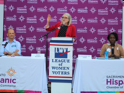 Assembly member Kevin McCarty and epidemiologist Dr. Flo Cofer listen to forum moderator Paula Lee at Casa de Español in Sacramento, Calif., on Sept. 30, 2024.