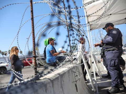 A U.S. Customs and Border Protection agent checks pedestrians' documentation at the San Ysidro Port of Entry in San Ysidro, California.