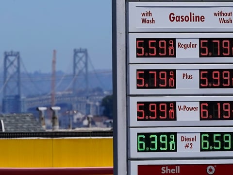 The San Francisco-Oakland Bay Bridge rises behind the price board of a gas station in San Francisco on July 20, 2022.